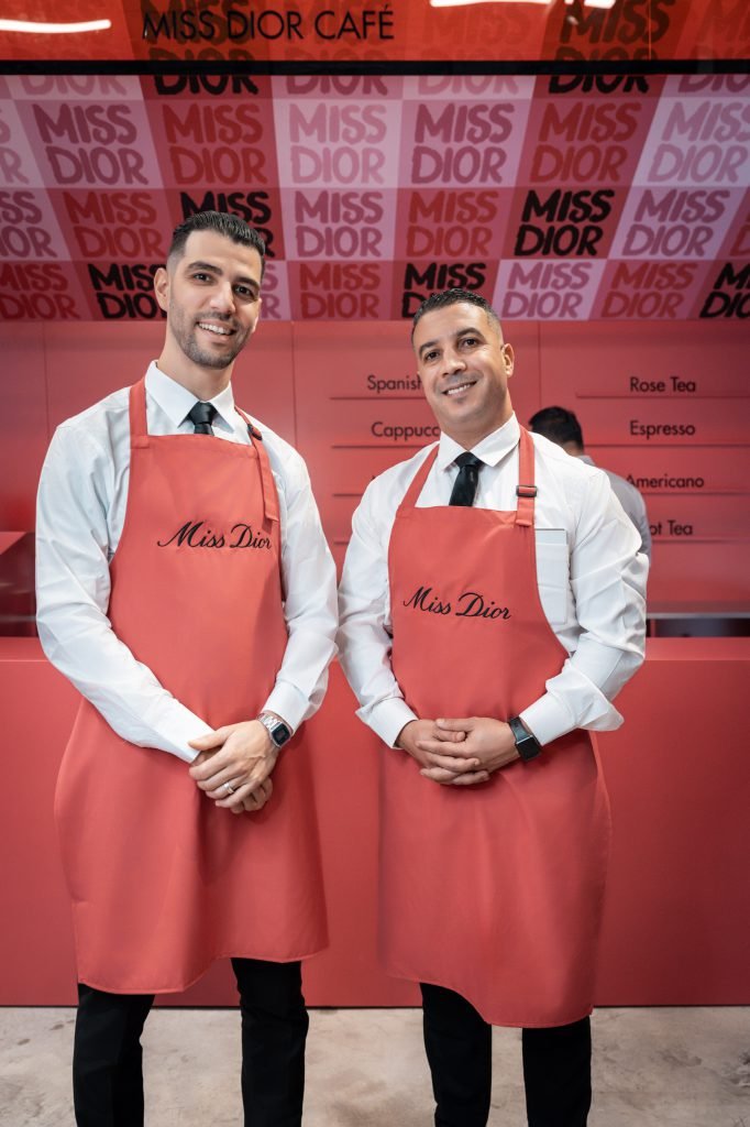 Baristas in Miss Dior aprons at the café counter