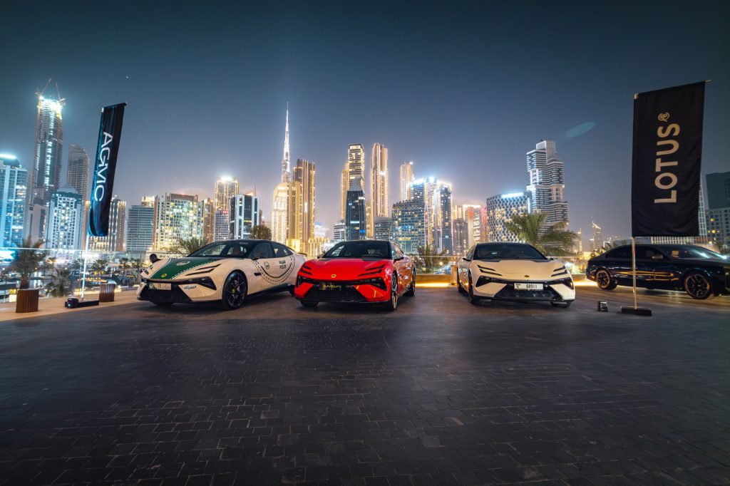 Lotus cars on display against the Dubai skyline at dusk